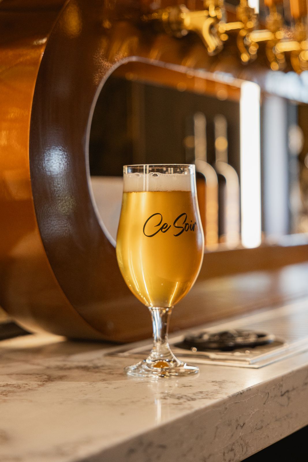 Ce Soir branded beer glass on the bar